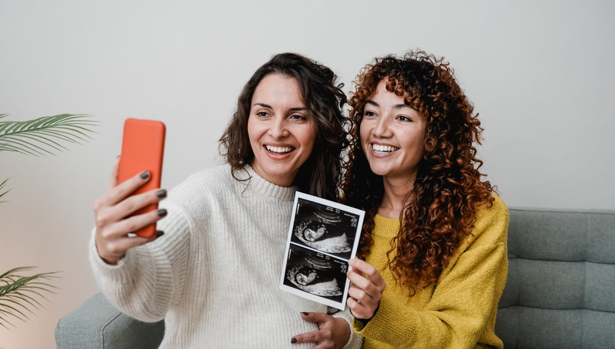 LGBT lesbian couple holding ultrasound photo after using donor sperm