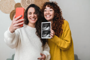 LGBTQ+ couple holding ultrasound after using donor sperm in fertility treatment