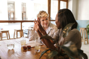 Two young women at a table talking about the Conceive Later Egg Freezing program offered by Conceive NJ | Wall Township, NJ